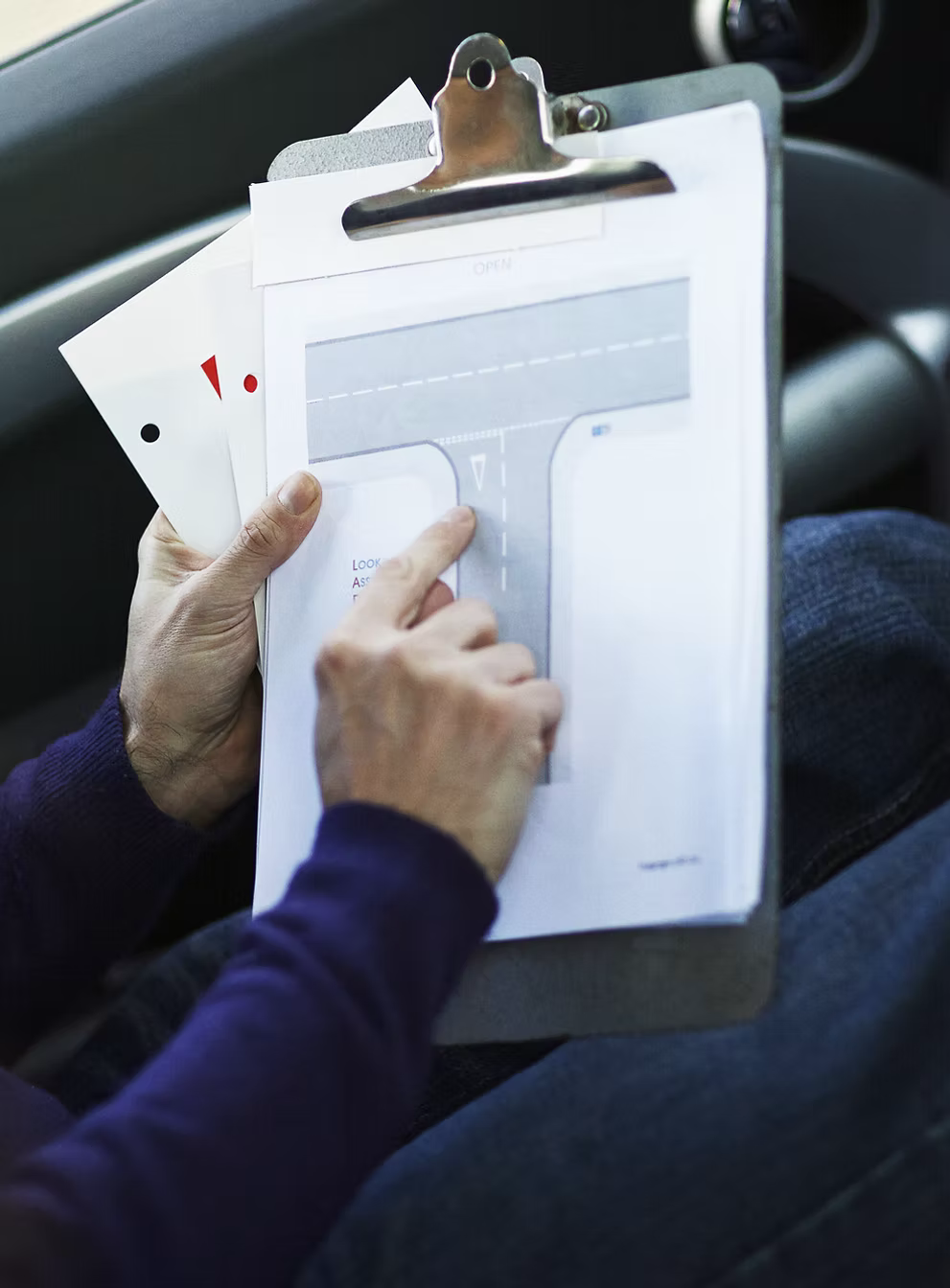 A driver education instructor's clipboard with a diagram of a proper turning technique fastened to it